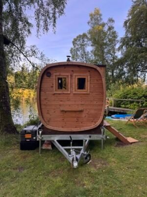 Set forfra: TimberIN Nordic Square mobil sauna på trailer ved en sø