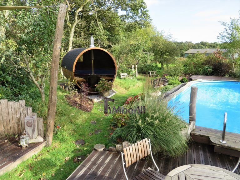 TimberIN® Danmark 11 Saunatønde i træ i en have ved en swimmingpool