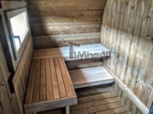 TimberIN Nordic Oval™ Terrace – udendørs sauna med terrasse set indefra, med tomt og tørt interiør, synlige træbænke, synligt vindue og synligt trægulv