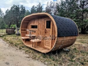 TimberIN Nordic Oval™ Terrace – udendørs sauna med terrasse, med synlige træbænke, synlig trædør, synligt vindue og sort tag, i en anlagt have