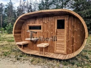 TimberIN Nordic Oval™ Terrace – udendørs sauna med terrasse set indefra, med synlige træbænke, synlig trædør og synligt vindue, i en anlagt have