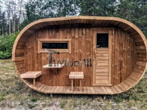 TimberIN Nordic Oval™ Terrace – udendørs sauna med terrasse, med synlige træbænke, synlig trædør, synligt vindue og havebord i nærheden