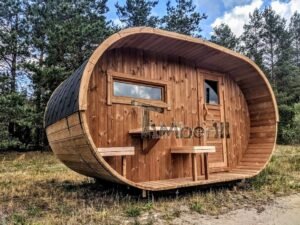 TimberIN Nordic Oval™ Terrace – udendørs sauna med terrasse, med synlige træbænke og synligt vindue, i en anlagt have