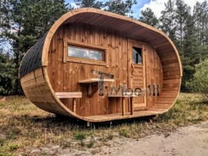 TimberIN Nordic Oval™ Terrace – udendørs sauna med terrasse, med synlig trædør, synligt vindue og gamle træer i baggrunden, i skovomgivelser