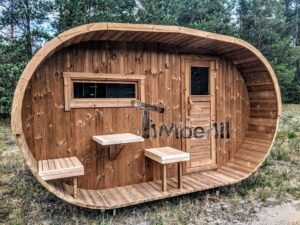 TimberIN Nordic Oval™ Terrace – udendørs sauna med terrasse set indefra, med synlige træbænke, synlig trædør og synligt vindue, i en anlagt have
