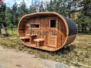 TimberIN Nordic Oval™ Terrace – udendørs sauna med terrasse, med synlige træbænke, synligt vindue og havebord i nærheden, i en anlagt have