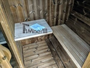 TimberIN Nordic Oval™ Terrace havesauna set indefra, med lang lys træbænk til højre, lille svævende hylde med brochure til venstre og mørkt lægtegulv