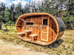 TimberIN Nordic Oval™ Terrace – udendørs sauna med terrasse set indefra, med synlige træbænke, synlig trædør og synligt vindue, på en åben eng