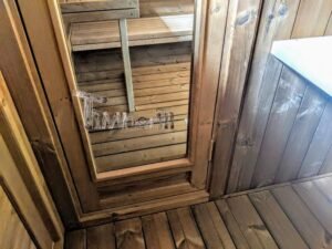 TimberIN Nordic Oval™ Terrace – udendørs sauna med terrasse, med tomt og tørt interiør og synlig trædør