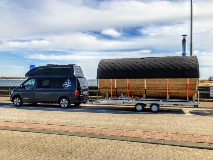 Varevogn trækker en mobil tøndesauna på trailer