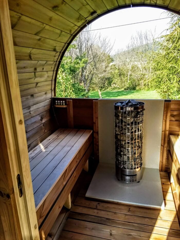 Sauna indefra med saunaovn og vindue med udsigt til haven