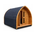 TimberIN Glamp Pod™ – buet glamping-pod i træ med sort shingeltag, dobbeltdør med glas og lille overdækket veranda på hvid baggrund.