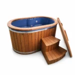 TimberIN Nordic Duo™ – ovalt vildmarksbad til to personer med blå glasfiberindsats, termotræbeklædning, trætrappe og åbent isoleret låg på hvid baggrund.