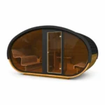 TimberIN Nordic Hobbiton™ Glass – bred oval sauna med mørk shingelbeklædning, panoramafront i glas, glasdør i midten og buede træbænke på hvid baggrund.