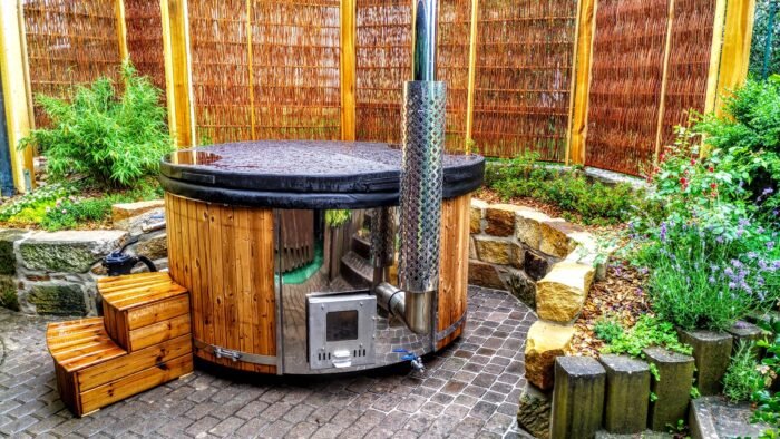 Vildmarksbad i træ med udvendig ovn og skorsten på en terrasse